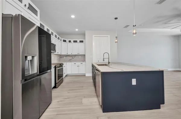 a kitchen with stainless steel appliances granite countertop a refrigerator a sink and a stove