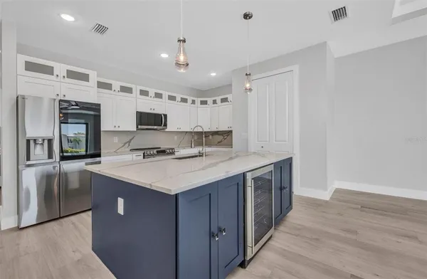 a kitchen with kitchen island a sink appliances and cabinets