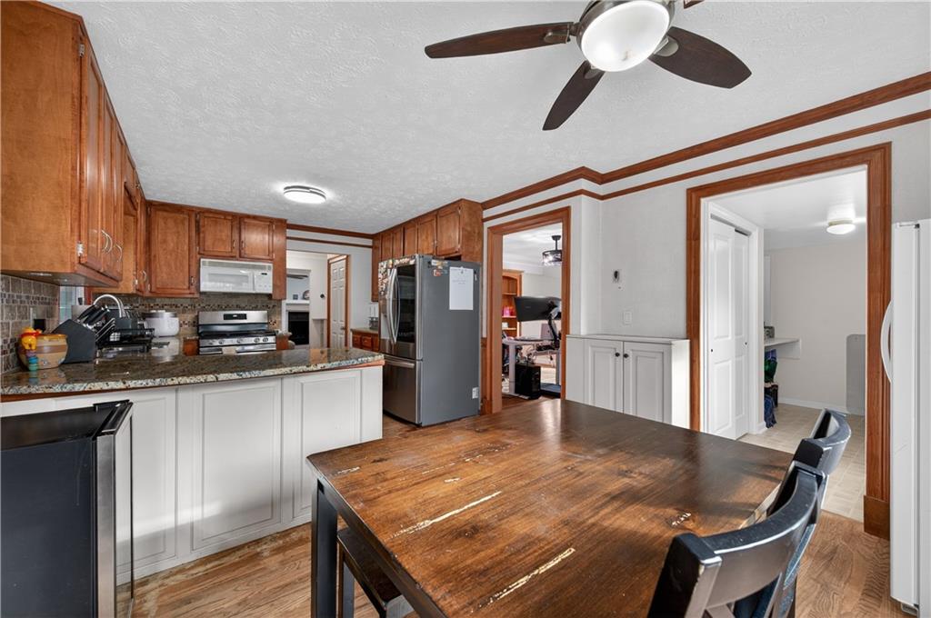2878 Cardinal Trace Duluth, GA 30096 - Photo 12 of 42 a kitchen with stainless steel appliances kitchen island granite countertop a refrigerator a stove top oven a sink dishwasher and wooden cabinets