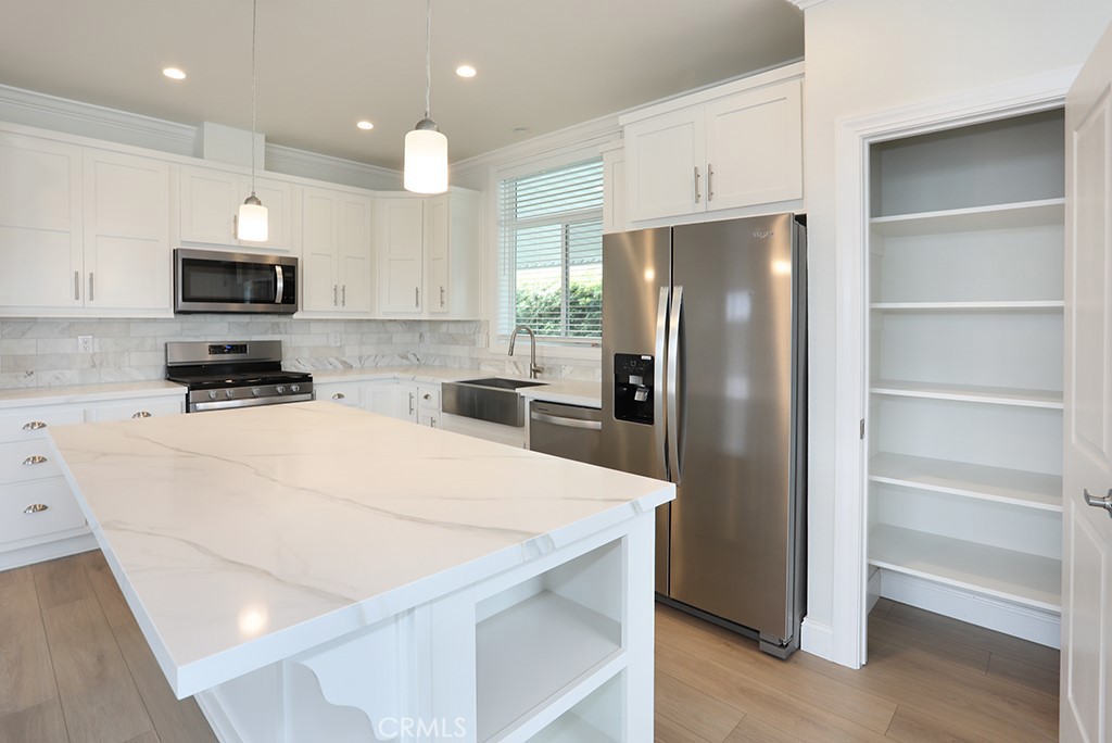 129 La Ronda Tustin, CA 92780 - Photo 5 of 33 a kitchen with stainless steel appliances a refrigerator stove microwave and cabinets