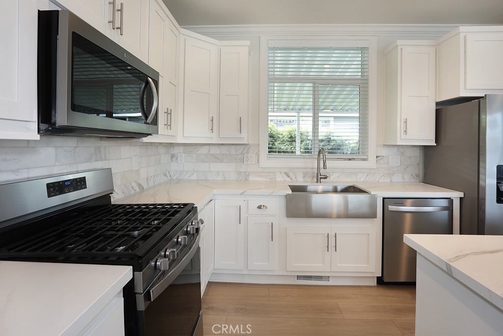 129 La Ronda Tustin, CA 92780 - Photo 7 of 33 a kitchen with a stove a sink and a microwave