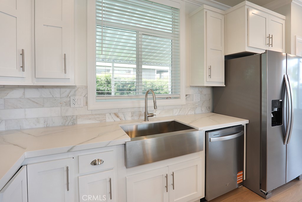 129 La Ronda Tustin, CA 92780 - Photo 8 of 33 a kitchen with a sink a refrigerator and cabinets