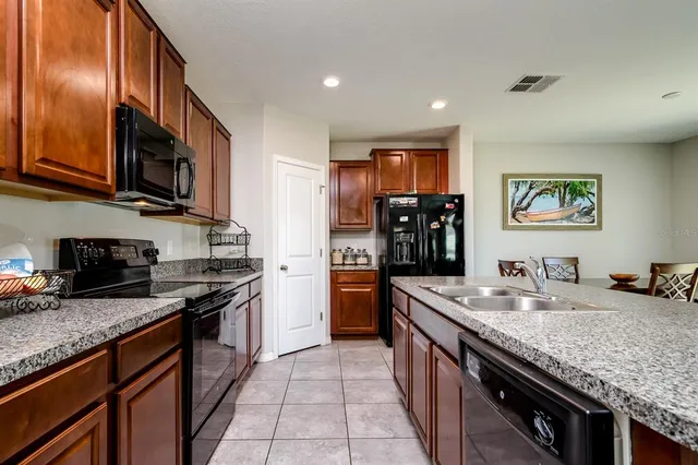 a kitchen with granite countertop stainless steel appliances and wooden cabinets