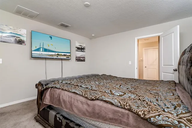 a bedroom with a bed and painting on the wall