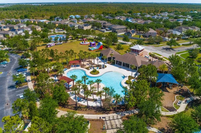 an aerial view of residential houses with outdoor space and trees