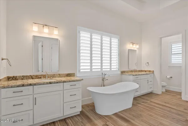 a bathroom with a granite countertop sink a mirror and a bathtub