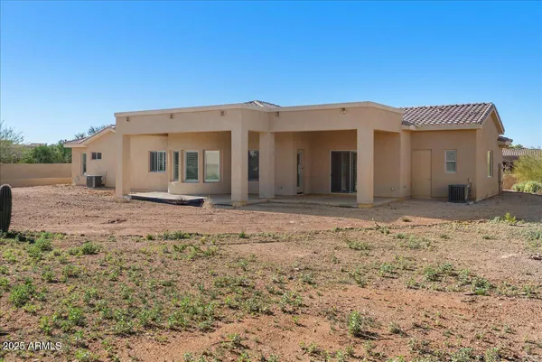 a view of a dry yard with green space