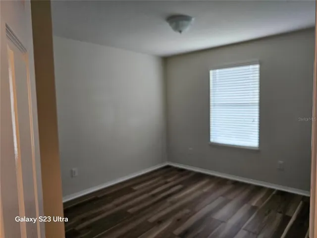 a room with wooden floor and a window
