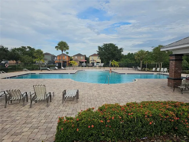 a view of a white house with large windows and a large tree