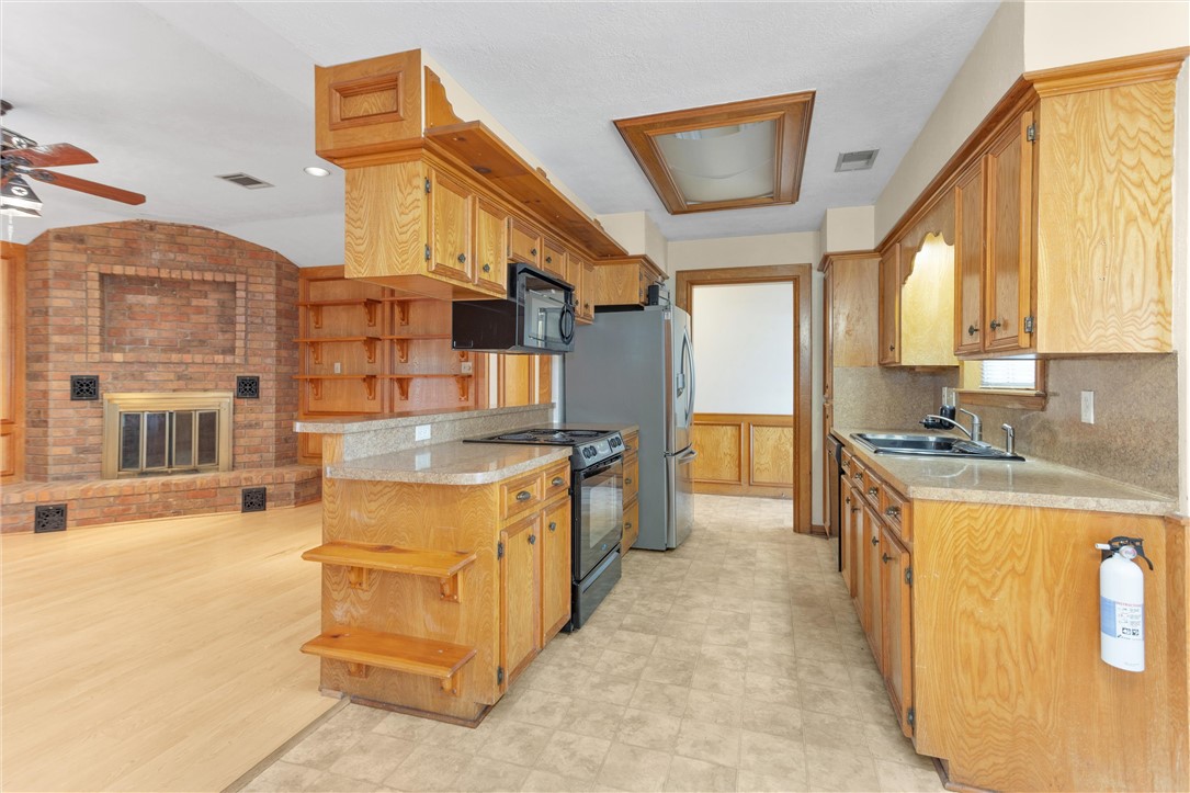 1706 Shawnee Street Navasota, TX 77868 - Photo 23 of 25 a large kitchen with stainless steel appliances granite countertop a large stove a sink and a refrigerator
