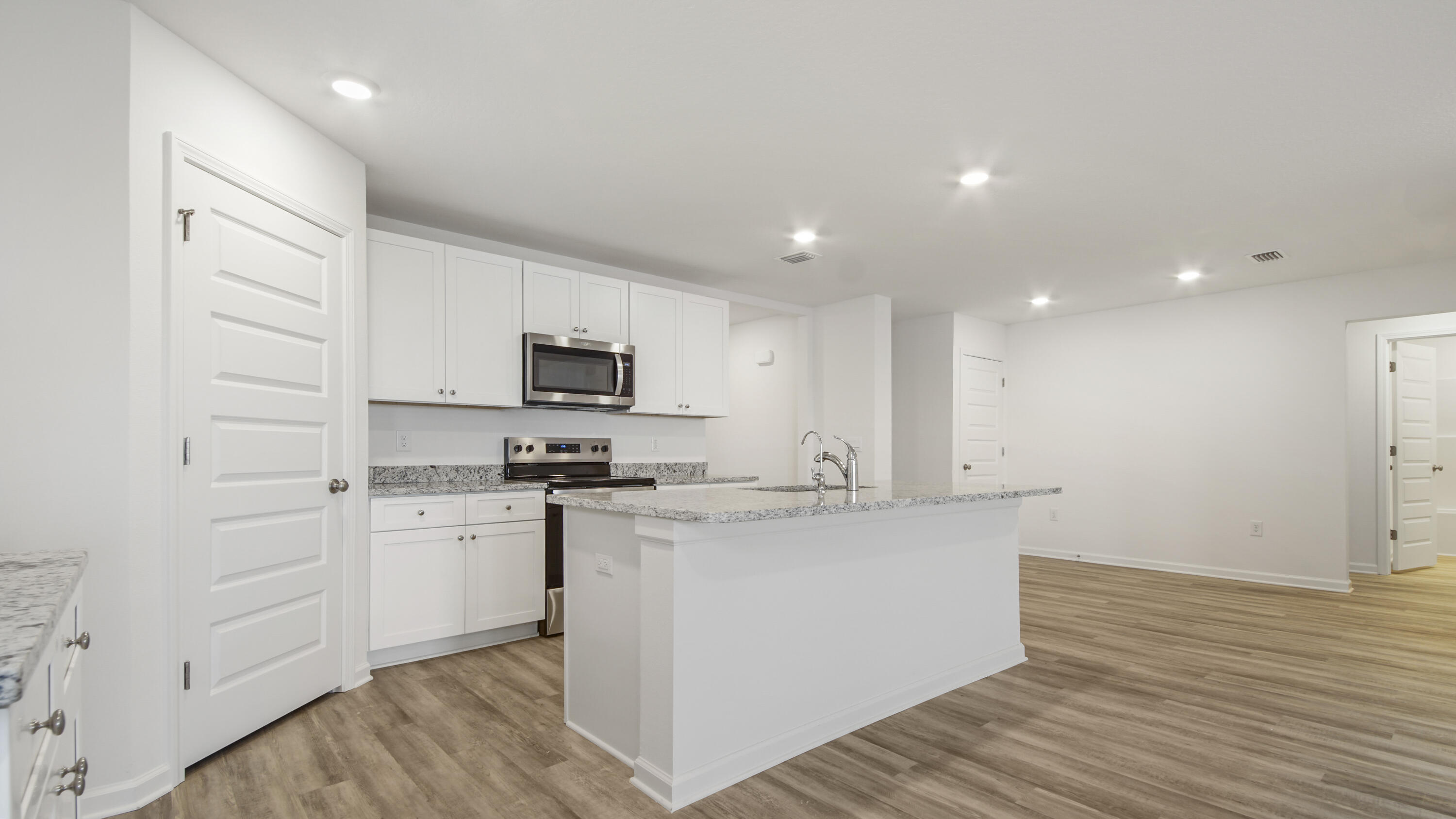 234 Gray Owl Drive Freeport, FL 32439 - Photo 12 of 37 a kitchen with stainless steel appliances granite countertop a stove top oven a sink a refrigerator white cabinets and wooden floor