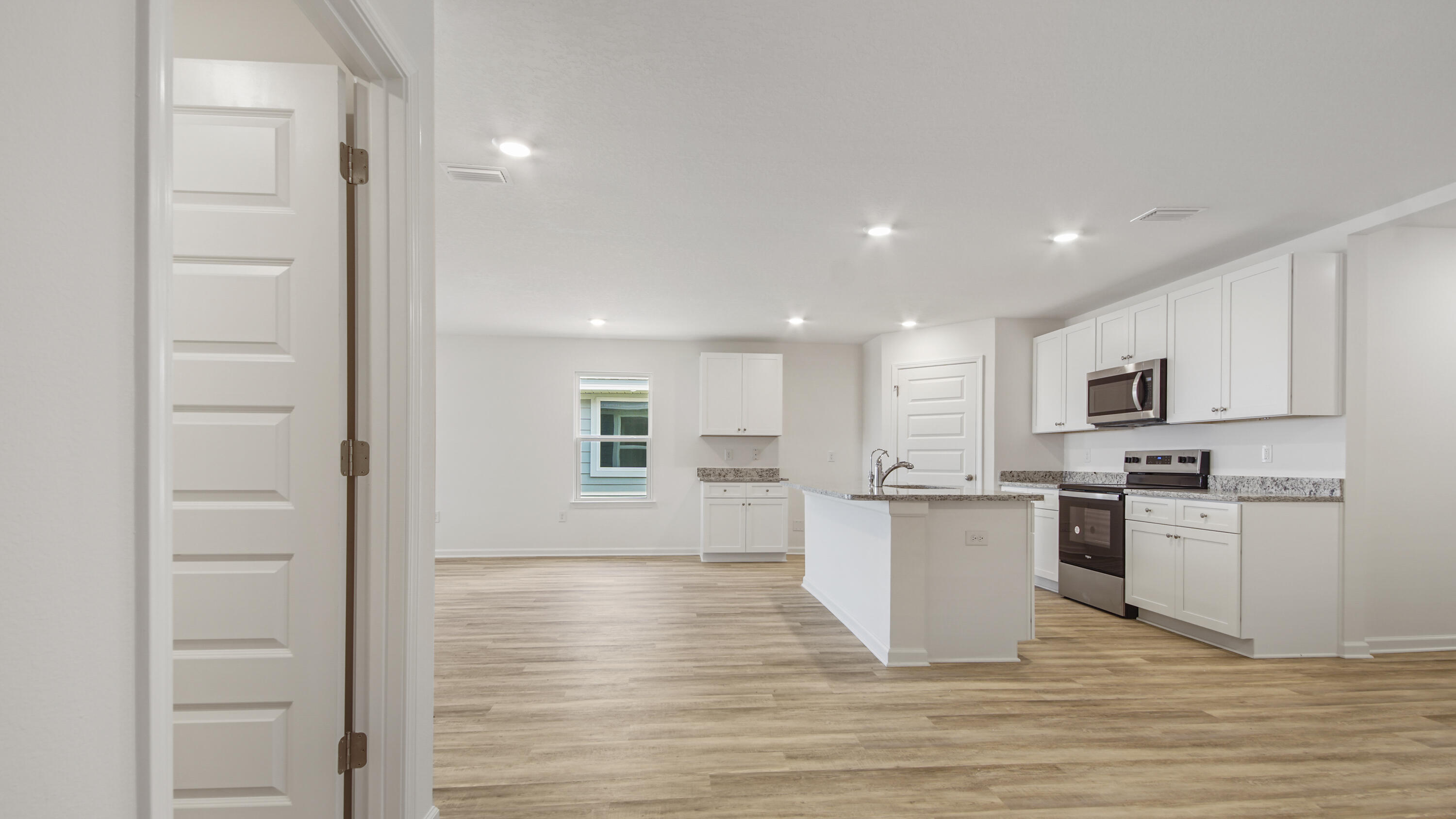 234 Gray Owl Drive Freeport, FL 32439 - Photo 23 of 37 a kitchen with stainless steel appliances granite countertop a stove top oven a sink a refrigerator and white cabinets with wooden floor