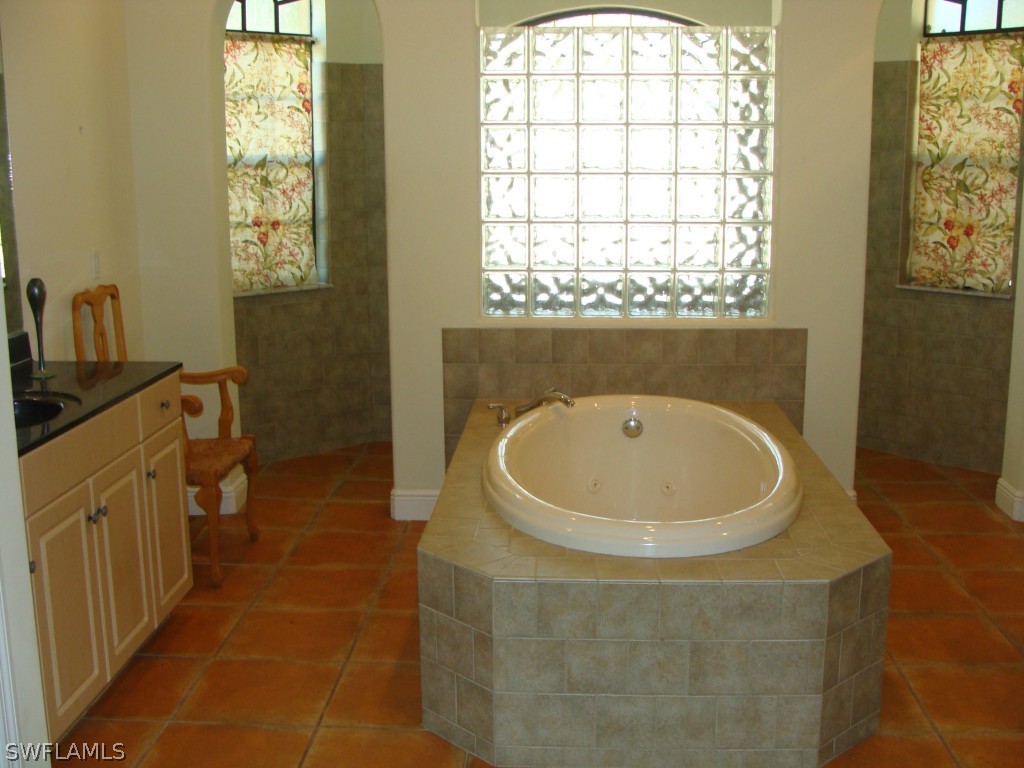 13710 Robert Road Bokeelia, FL 33922 - Photo 11 of 24 a bathroom with a sink a window and a mirror