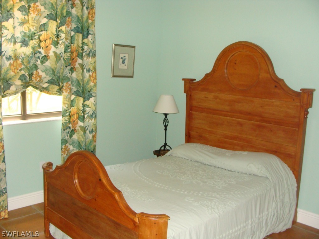 13710 Robert Road Bokeelia, FL 33922 - Photo 12 of 24 a bedroom with a bed and a window