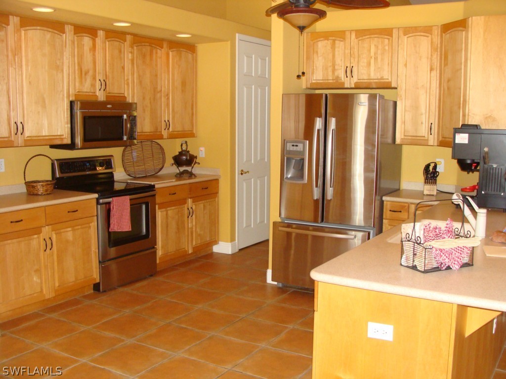 13710 Robert Road Bokeelia, FL 33922 - Photo 5 of 24 a kitchen with a sink a stove and a refrigerator