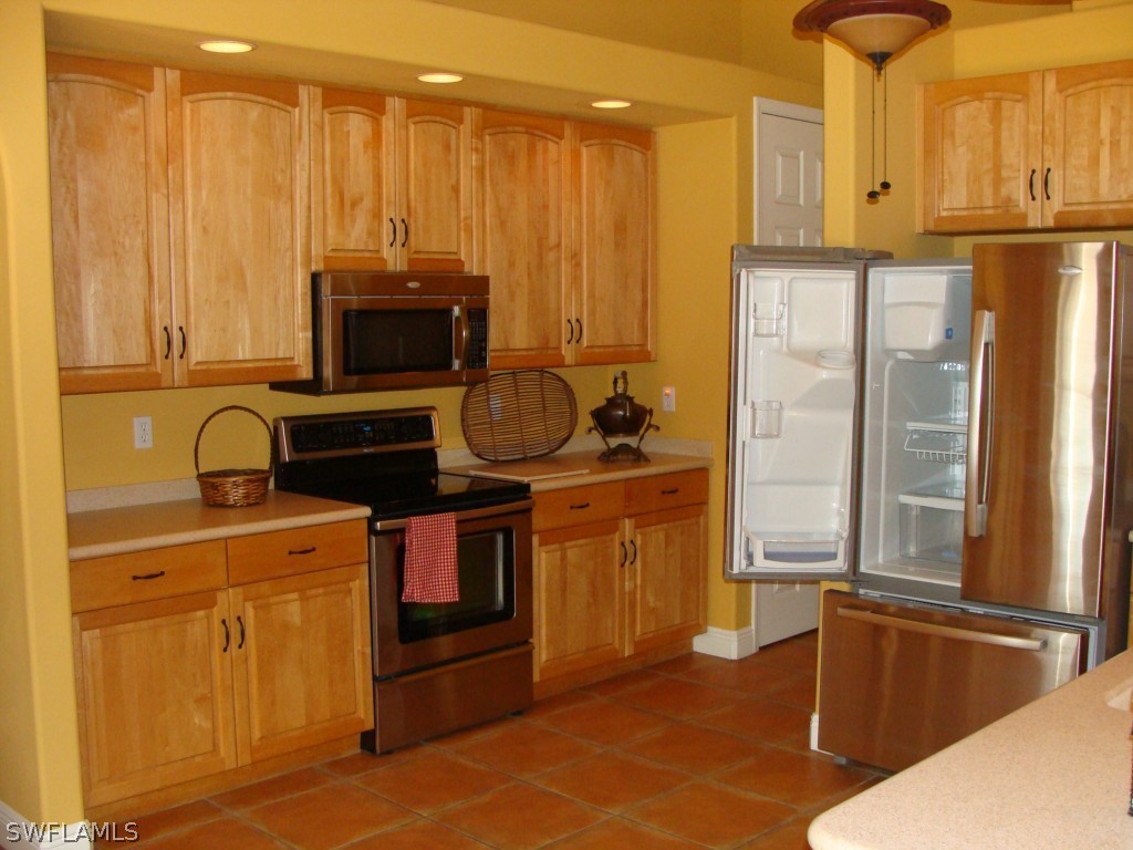 13710 Robert Road Bokeelia, FL 33922 - Photo 6 of 24 a kitchen with a refrigerator and a stove