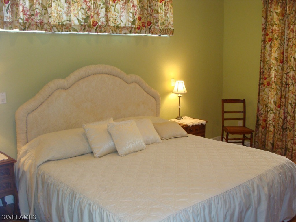 13710 Robert Road Bokeelia, FL 33922 - Photo 8 of 24 a bedroom with a bed and a wooden floor