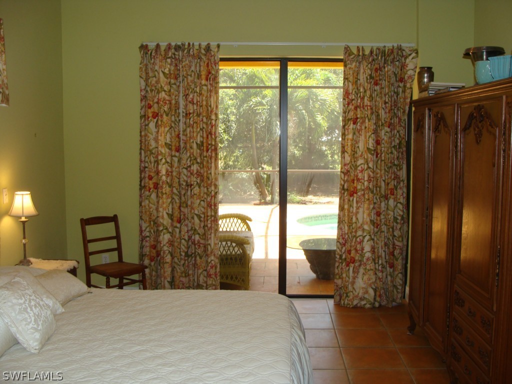 13710 Robert Road Bokeelia, FL 33922 - Photo 9 of 24 a bedroom with a bed and a window