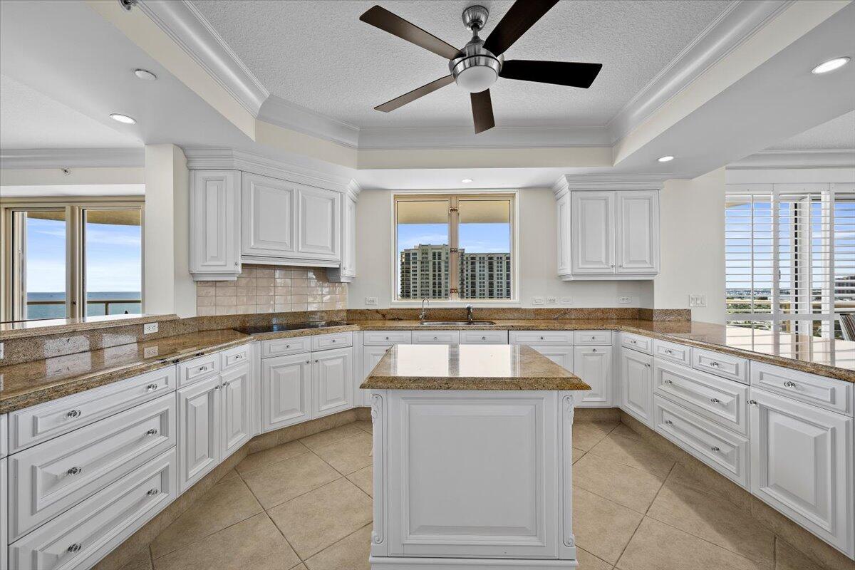 3920 North Ocean Drive, Unit 11B Singer Island, FL 33404 - Photo 14 of 58 a kitchen with granite countertop white cabinets white appliances a sink and a window