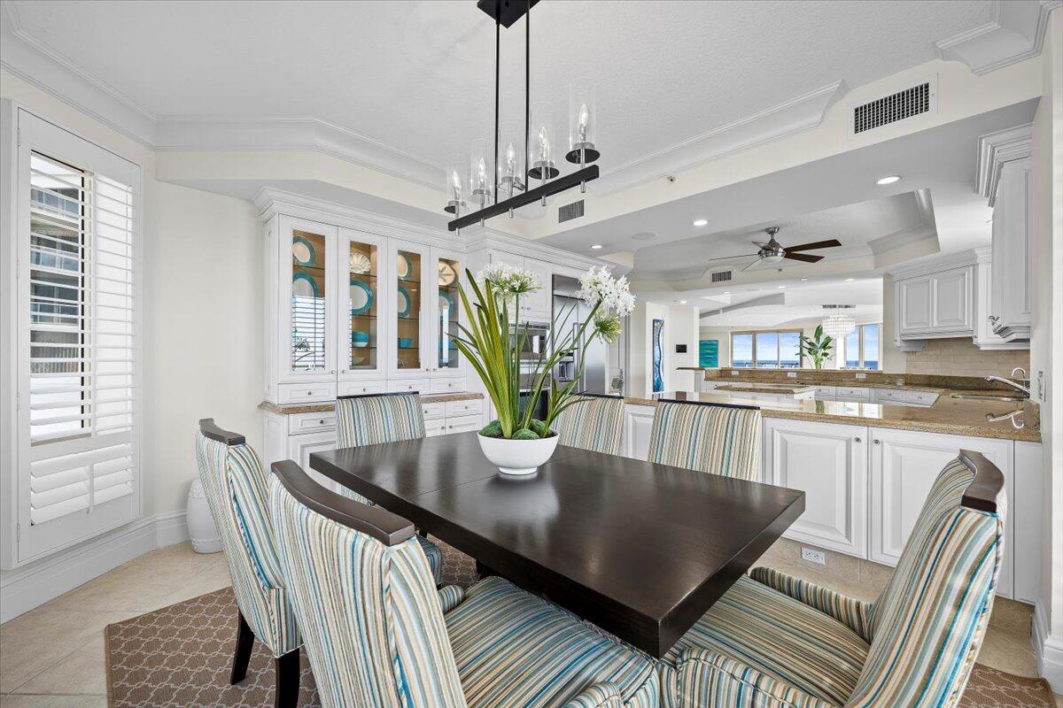 3920 North Ocean Drive, Unit 11B Singer Island, FL 33404 - Photo 16 of 58 a view of a dining room with furniture a chandelier and wooden floor