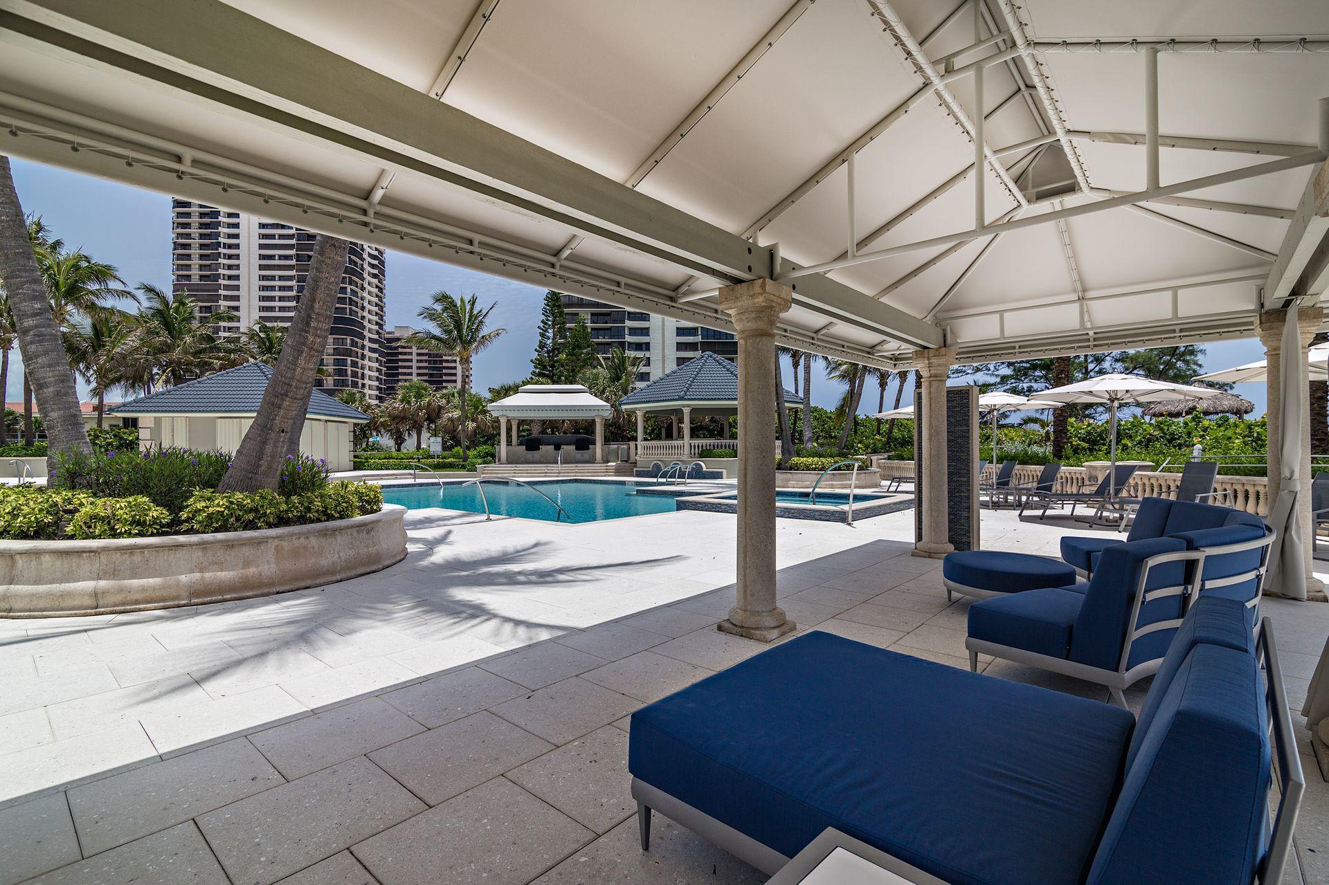 3920 North Ocean Drive, Unit 11B Singer Island, FL 33404 - Photo 37 of 58 a view of a patio with a dining table and chairs under an umbrella