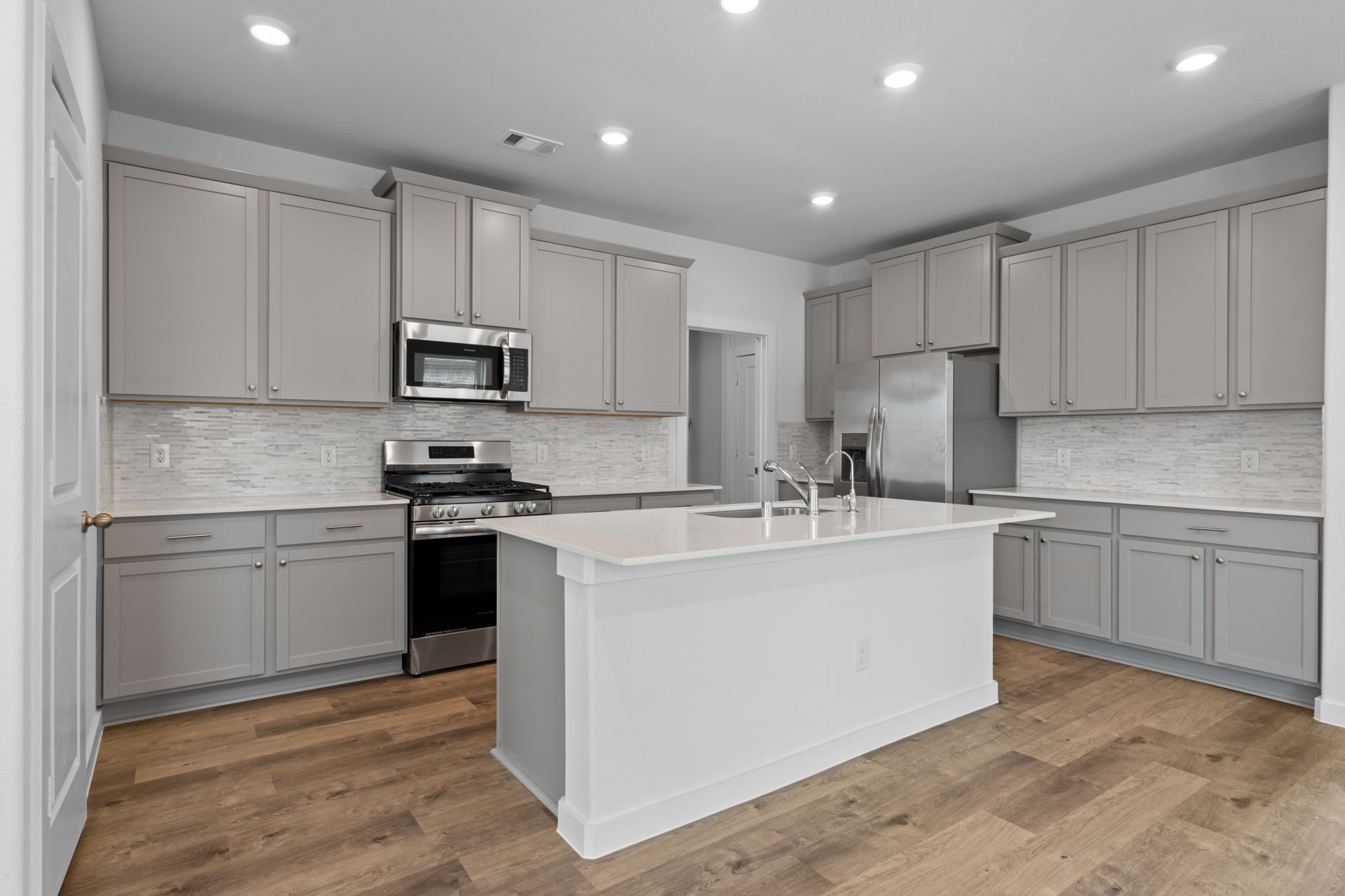 332 Gambels Quail Road Waller, TX 77484 - Photo 7 of 27 a kitchen with kitchen island a sink stainless steel appliances and cabinets