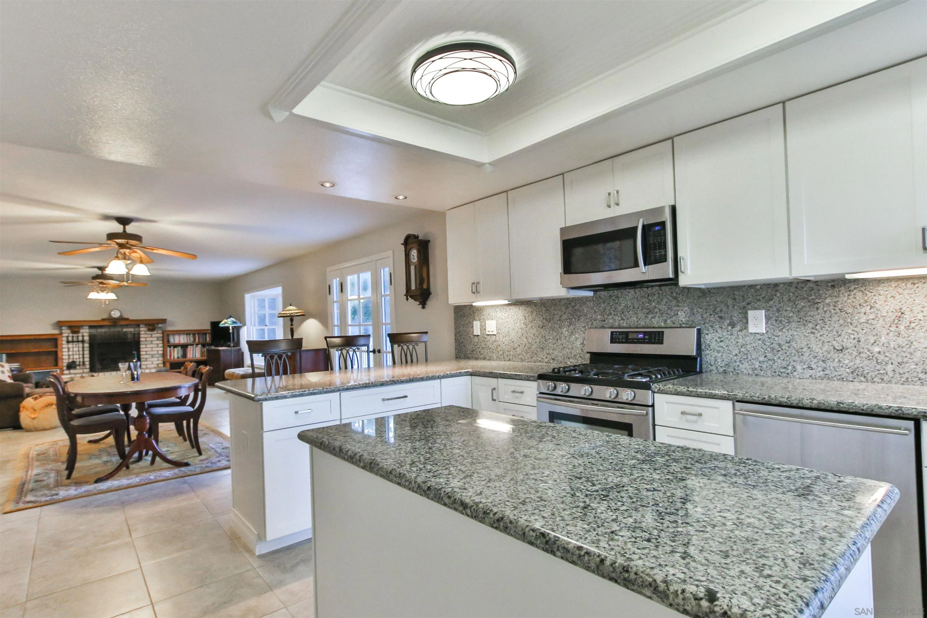 648 Norwynn Lane Fallbrook, CA 92028 - Photo 7 of 17 a kitchen with stainless steel appliances granite countertop a stove top oven a sink a dining table and chairs with wooden floor