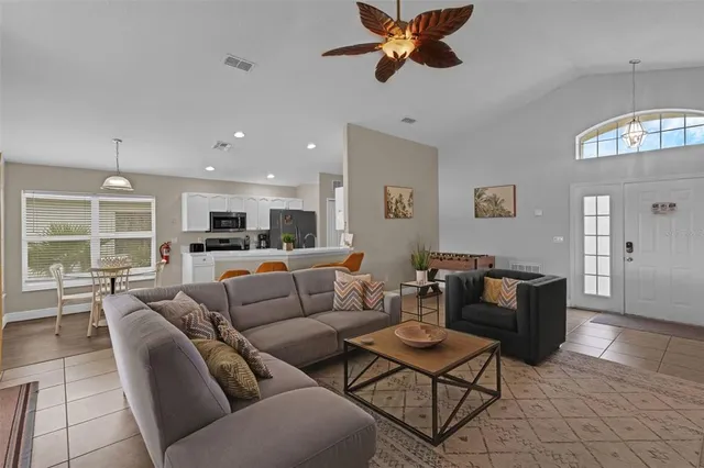 a living room with furniture kitchen view and a window