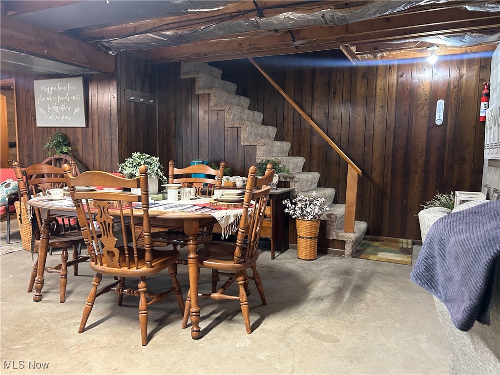 2242 South McCoy Ridge Road Stockport, OH 43787 - Photo 20 of 41 Dining room with stairs, wood walls, and unfinished concrete floors