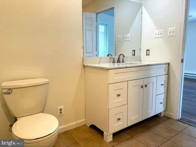 a bathroom with a toilet a sink and mirror