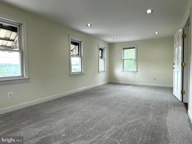 an empty room with windows and closet