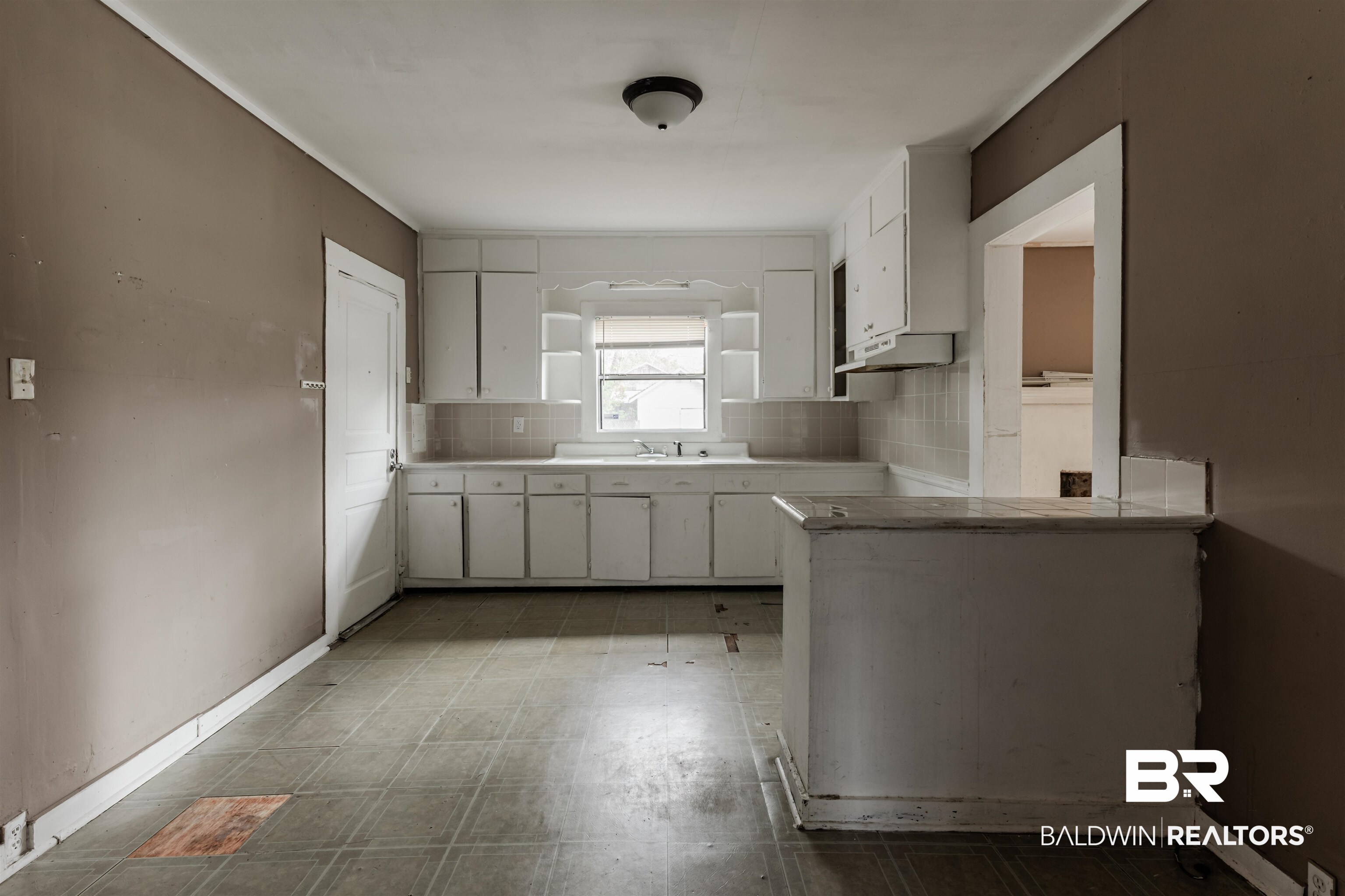 600 Mohawk Street Mobile, AL 36606 - Photo 12 of 20 Kitchen with white cabinetry, kitchen peninsula, and tasteful backsplash