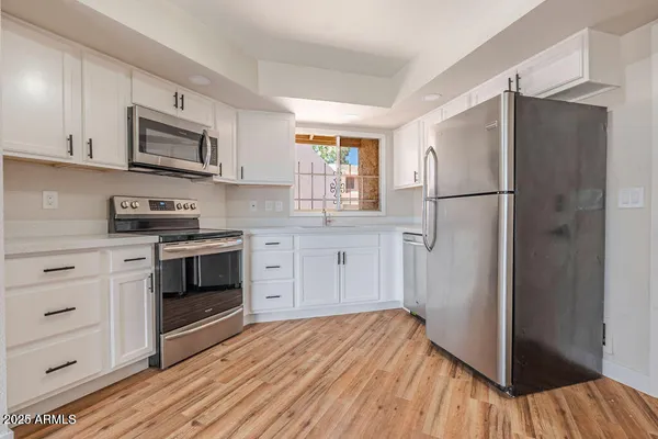 a kitchen with white cabinets and stainless steel appliances