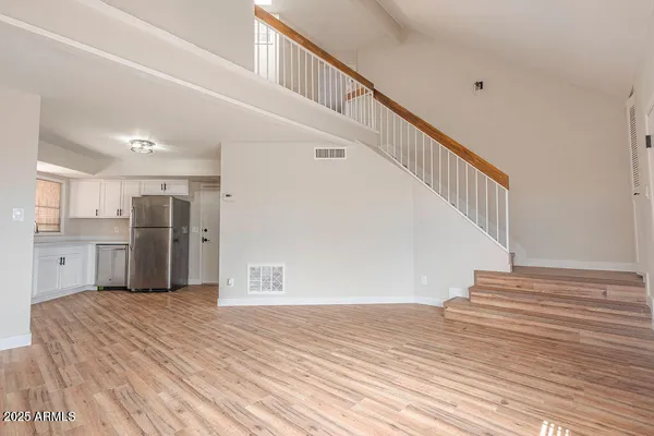 a view of a hallway with wooden floor and staircase