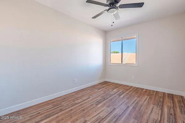 a view of a room with wooden floor and fan