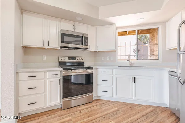 a kitchen with granite countertop a stove microwave and sink