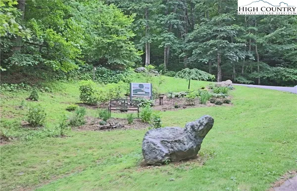 a view of a chair and table and garden in the back