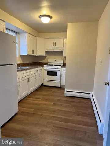 a kitchen with granite countertop white cabinets and white appliances