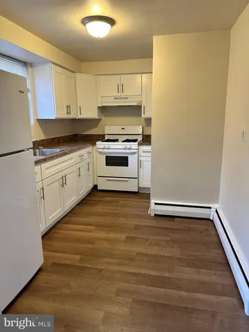 a kitchen with granite countertop a stove and white cabinets