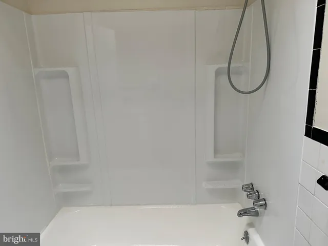 a bathroom with a white bath tub and a shower