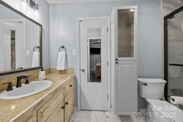 a bathroom with a granite countertop shower and a toilet