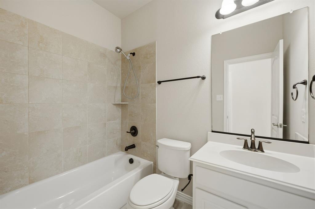 12809 Spring Hill Drive Frisco, TX 75035 - Photo 22 of 37 a bathroom with a toilet a sink and a bathtub