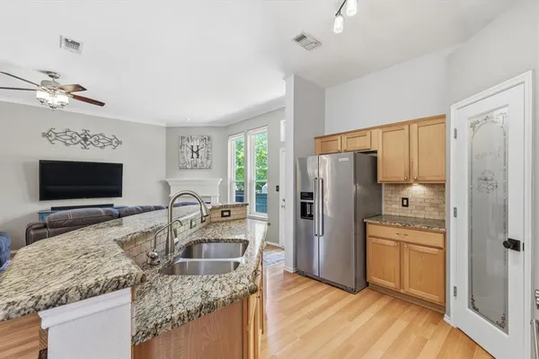 a kitchen with granite countertop a refrigerator stove and sink