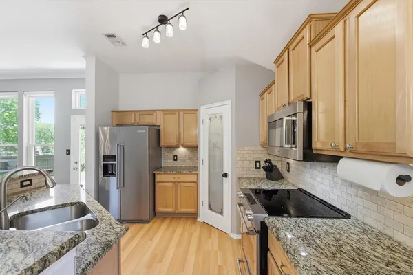 a kitchen with granite countertop a sink stove and refrigerator