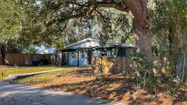 a view of a house with backyard and wooden fence
