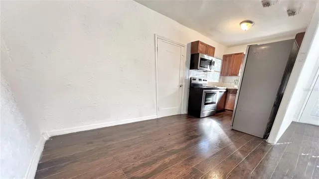 a view of a kitchen with wooden floor and electronic appliances