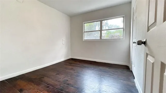 an empty room with wooden floor and a window