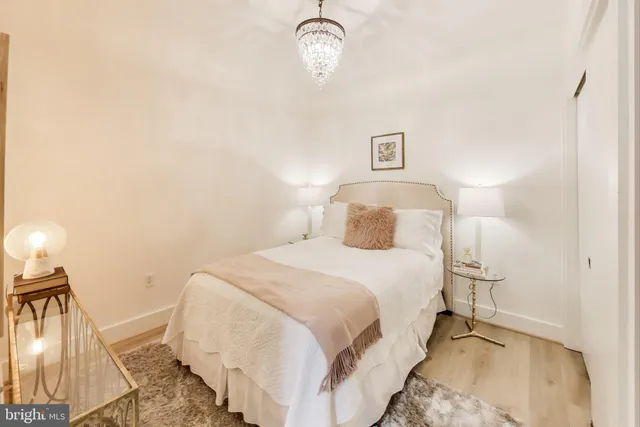 a bedroom with a bed and a lamp with wooden floor