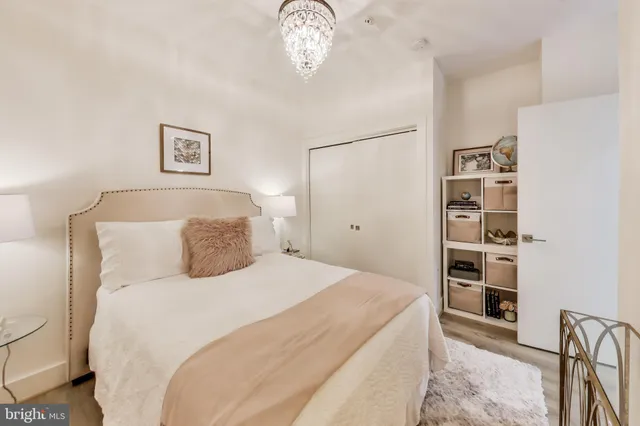 a bedroom with a large bed and a chandelier