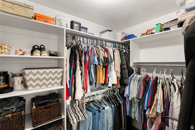2485 South 1100th Street West Logan, UT 84321 - Photo 21 of 53 Expansive walk-in closet featuring white built-in shelving, multiple hanging rods for clothing organization, and high upper shelves for additional storage